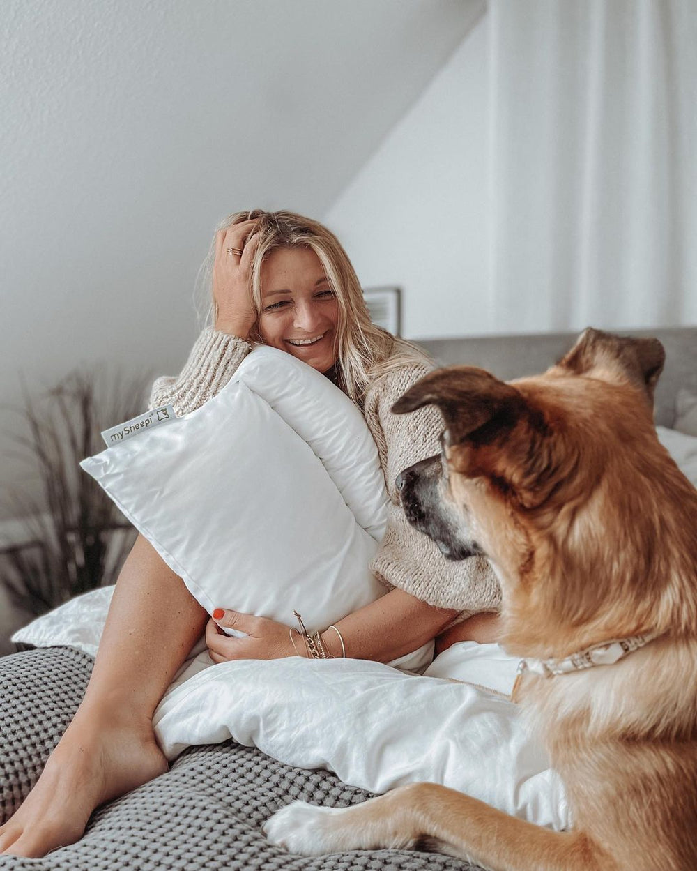 Glückliche Frau umarmt Kopfkissen