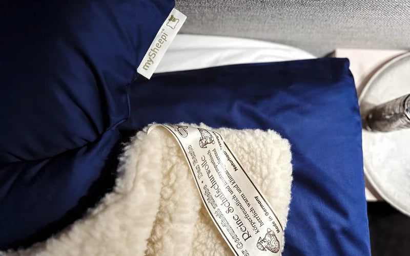 Bettdecke aus Schurwolle neben einem mySheepi Nackenkissen